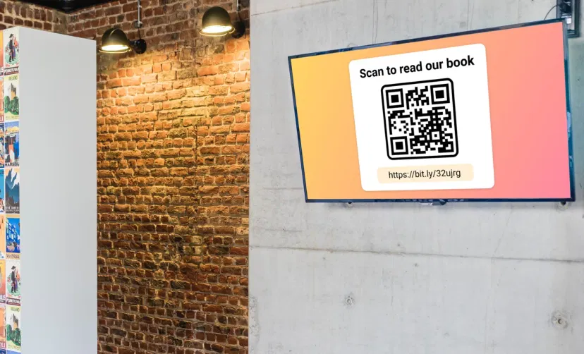 Digital signage screen placed in school library showing QR code using Pickcel software to read digital copy of a book